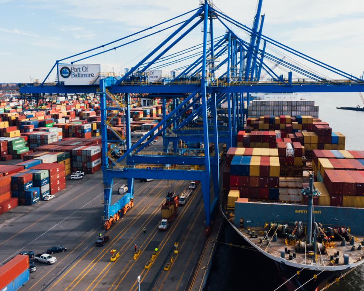 Cargo ship loading containers at a port, textiles moving between markets
