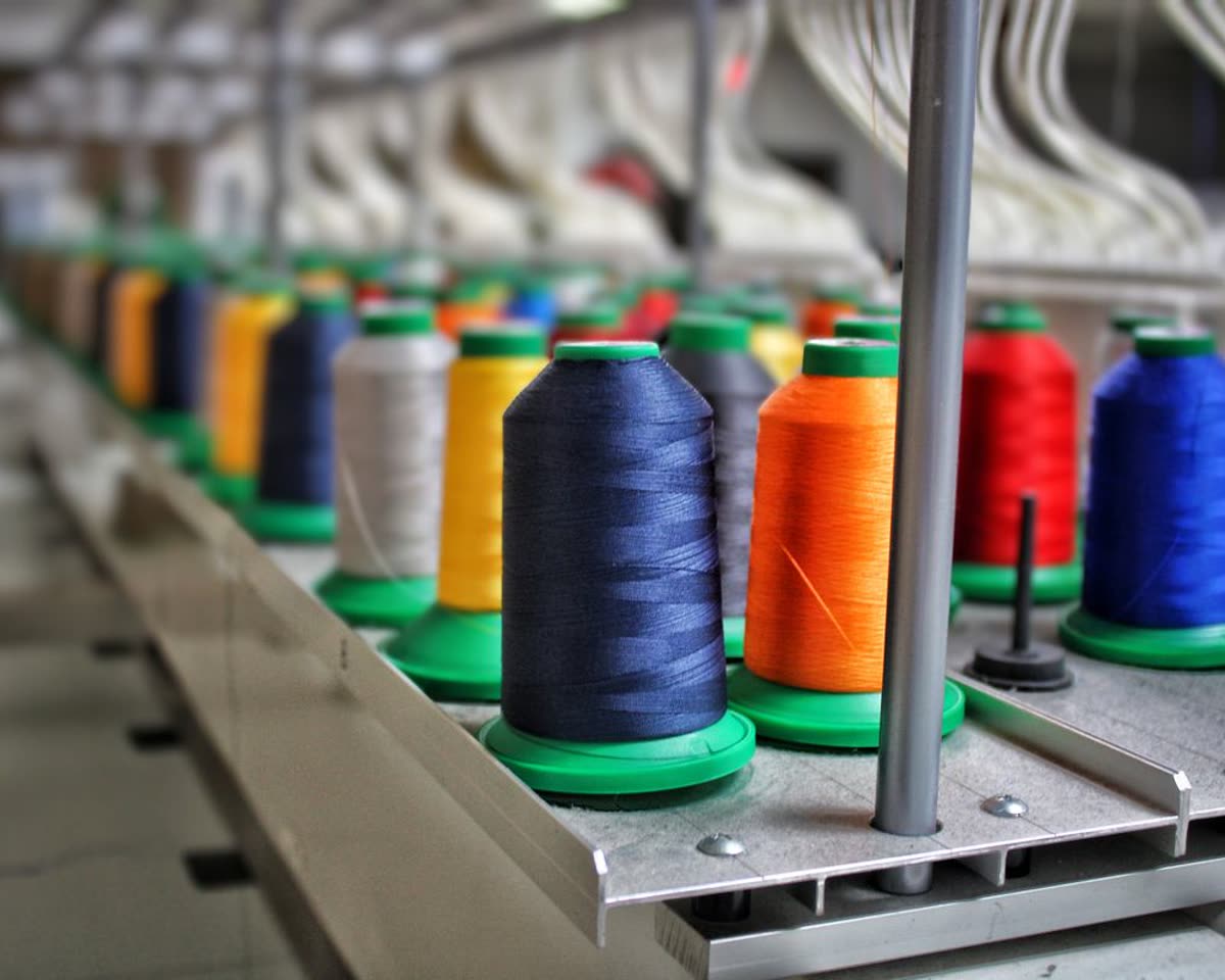 Rows of coloured yarn cones on a spinning frame in a textile mill